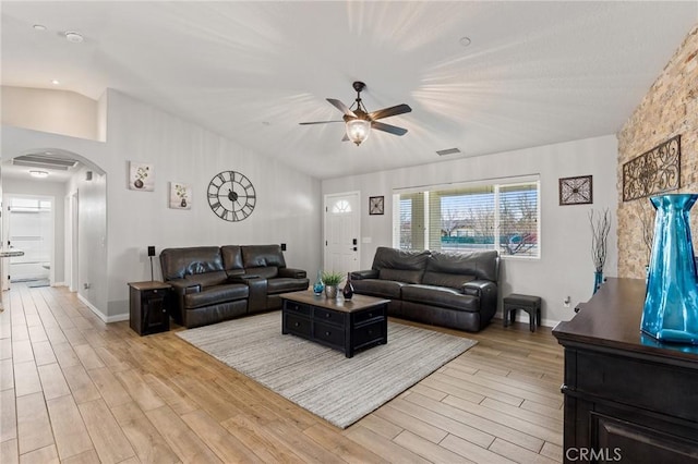 living room with lofted ceiling, ceiling fan, and light hardwood / wood-style flooring