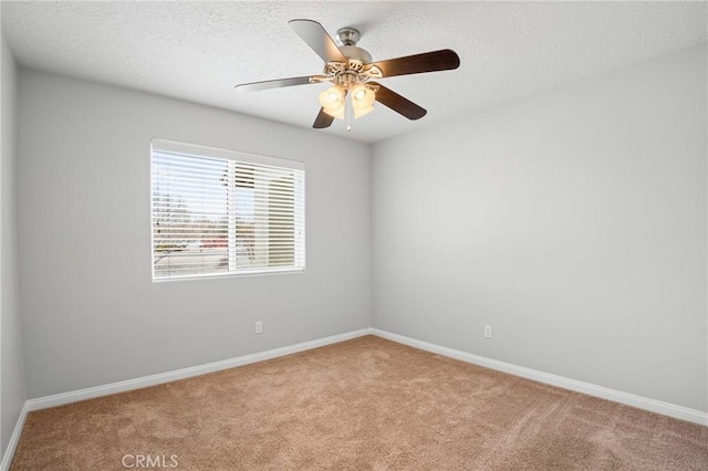 carpeted spare room with ceiling fan and a textured ceiling