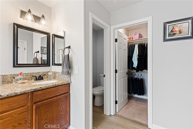 bathroom with hardwood / wood-style flooring, vanity, and toilet