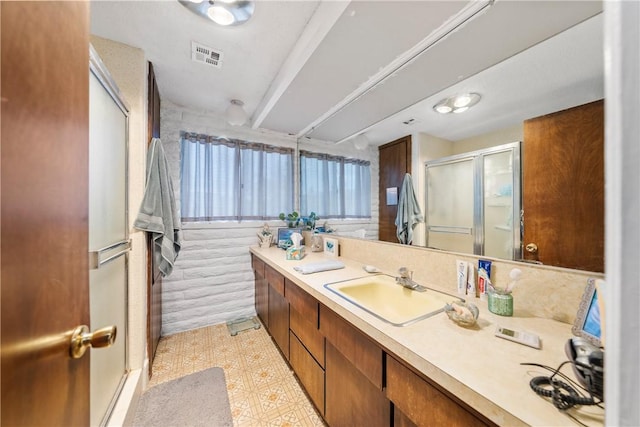 bathroom with vanity and a shower with shower door