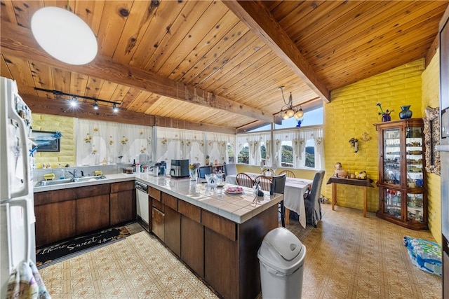 kitchen with lofted ceiling with beams, sink, white fridge, kitchen peninsula, and dark brown cabinets