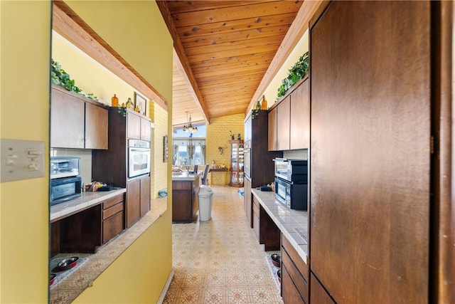 kitchen featuring beamed ceiling, wood ceiling, oven, and a chandelier