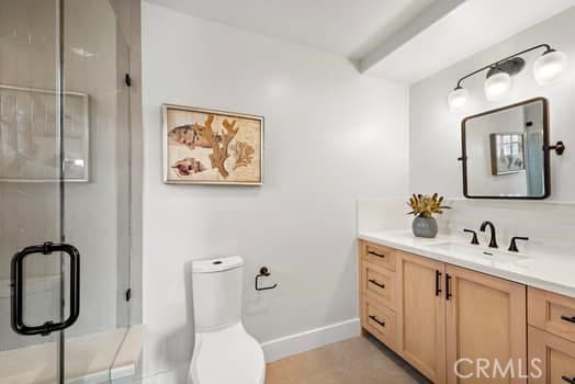 bathroom featuring vanity, a shower with shower door, and toilet