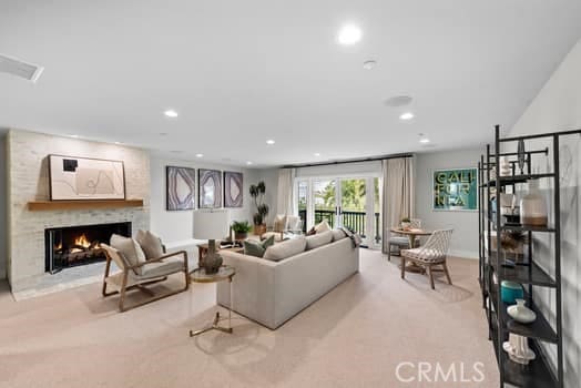 living room featuring a large fireplace and light colored carpet