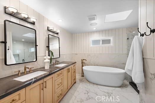 bathroom with vanity, separate shower and tub, and a skylight