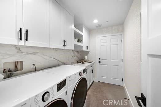 laundry area featuring cabinets, washer and dryer, and sink