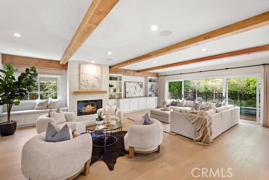 living room with light hardwood / wood-style flooring and beamed ceiling