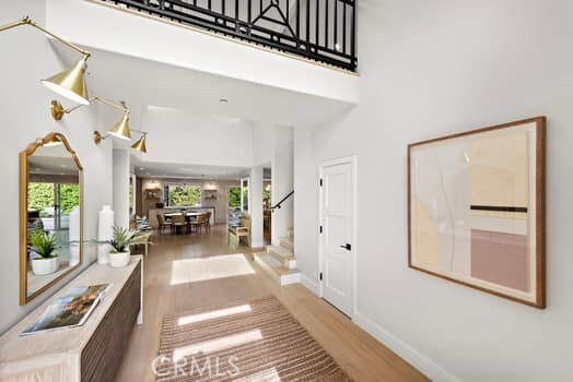 hall with hardwood / wood-style flooring, plenty of natural light, and a high ceiling