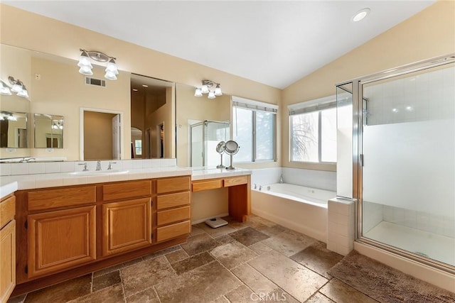 bathroom with lofted ceiling, vanity, and separate shower and tub