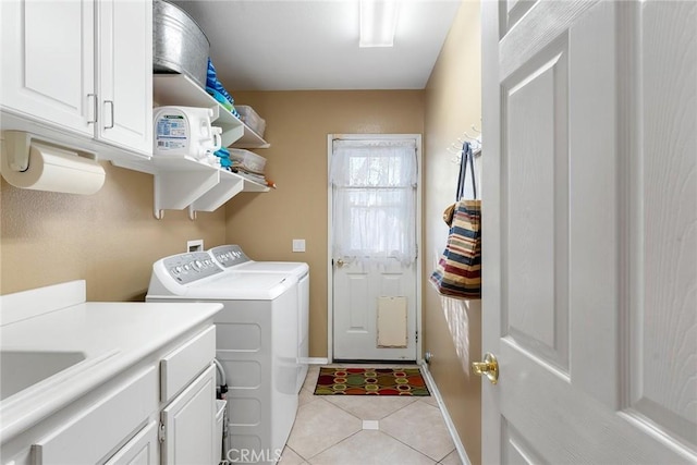 clothes washing area featuring light tile patterned flooring, cabinets, sink, and washing machine and dryer