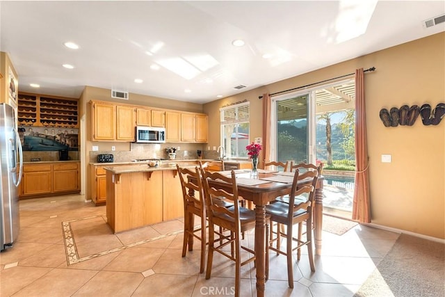 dining area featuring light tile patterned floors and sink