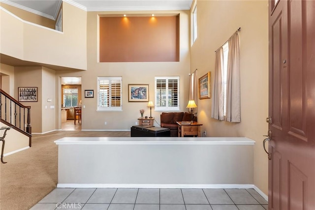 carpeted living room featuring ornamental molding and a high ceiling