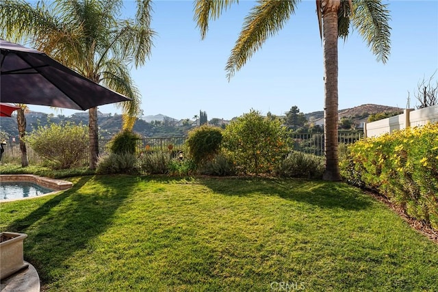 view of yard with a fenced in pool and a mountain view