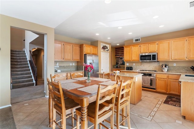 kitchen featuring stainless steel appliances, light brown cabinets, and light tile patterned floors