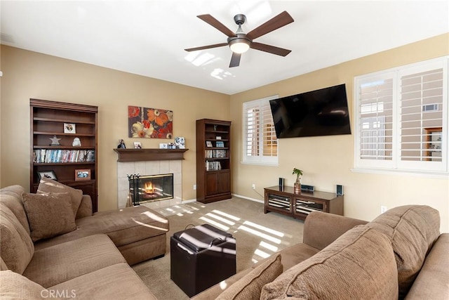 carpeted living room featuring a fireplace and ceiling fan