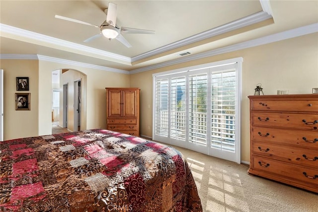 bedroom featuring crown molding, ceiling fan, access to exterior, a tray ceiling, and light colored carpet