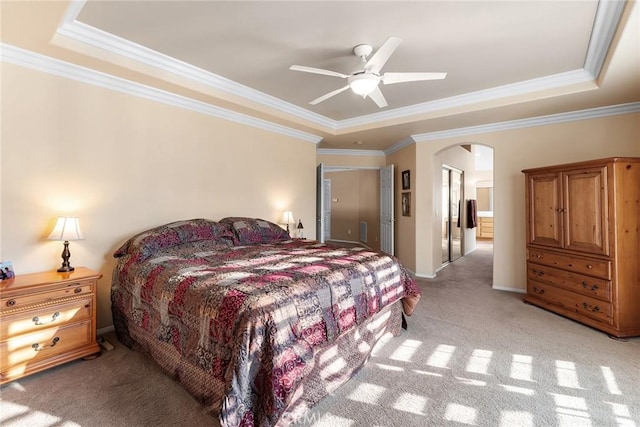 bedroom with light carpet, ornamental molding, a raised ceiling, and ceiling fan