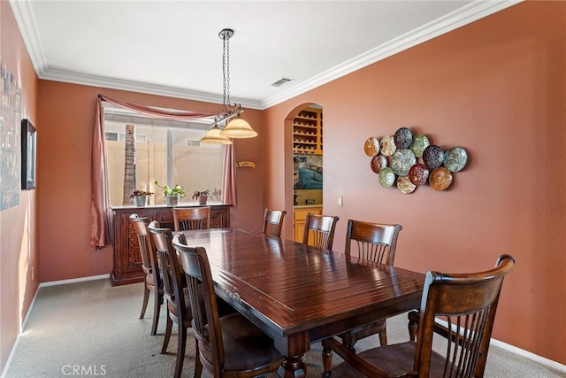 carpeted dining room featuring ornamental molding