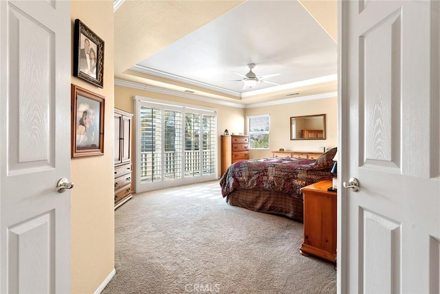 carpeted bedroom featuring a tray ceiling, access to outside, ornamental molding, and ceiling fan