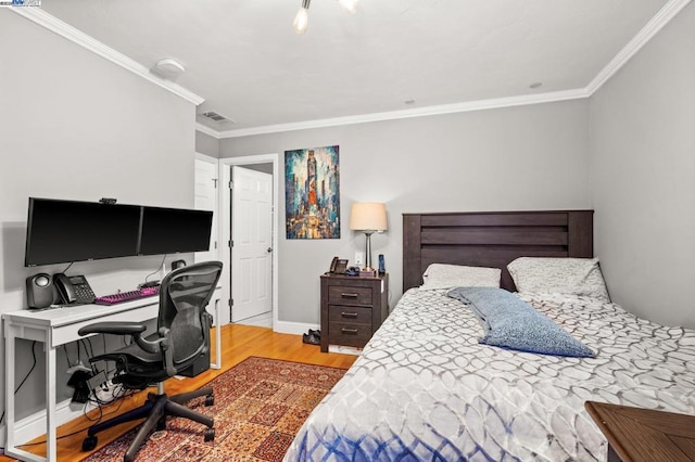 bedroom with ornamental molding and light wood-type flooring