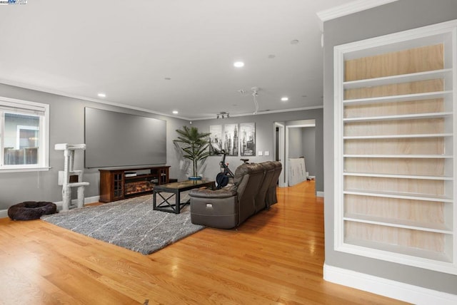 living room featuring crown molding, wood-type flooring, and built in features