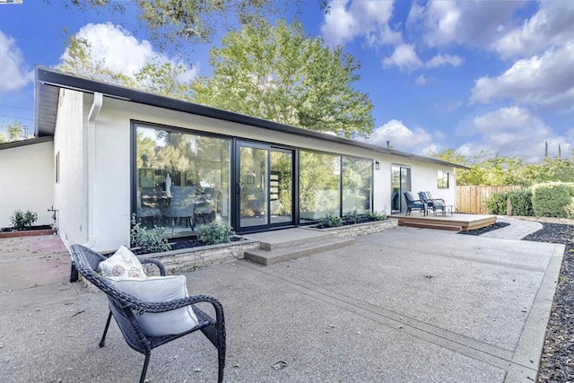 rear view of house featuring a patio and a wooden deck