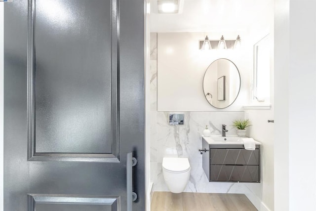 bathroom featuring vanity, wood-type flooring, and toilet