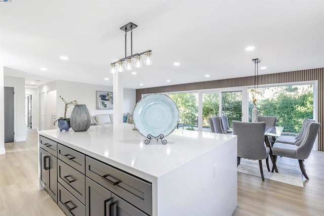 kitchen featuring pendant lighting, a center island, and light wood-type flooring