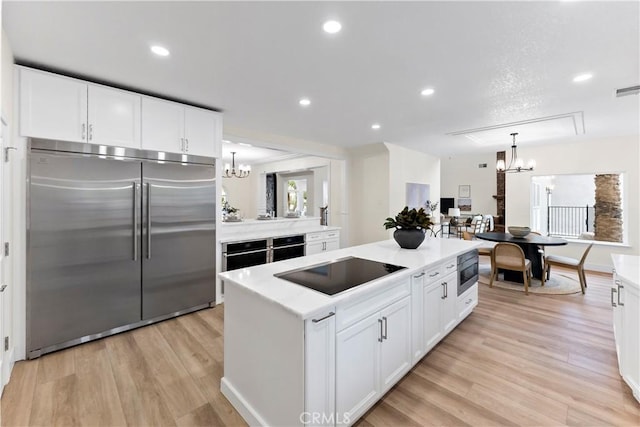 6054 N Woodson Ave, Fresno, CA 93711 - kitchen featuring light countertops, a notable chandelier, built in appliances, and a center island