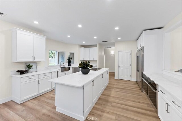 6054 N Woodson Ave, Fresno, CA 93711 - kitchen featuring recessed lighting, a sink, light wood-style floors, high quality fridge, and a center island