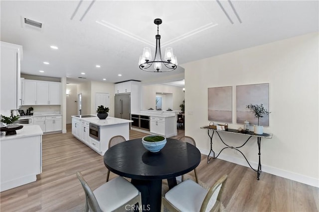 6054 N Woodson Ave, Fresno, CA 93711 - dining area with light wood finished floors, visible vents, baseboards, recessed lighting, and a notable chandelier