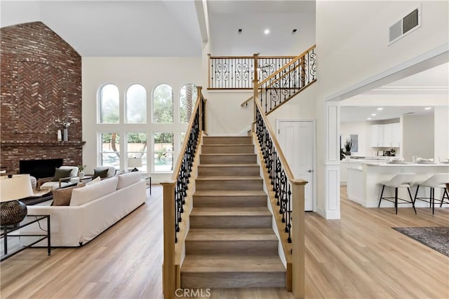 6054 N Woodson Ave, Fresno, CA 93711 - stairway featuring visible vents, high vaulted ceiling, wood finished floors, and a fireplace