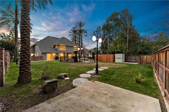 6054 N Woodson Ave, Fresno, CA 93711 - yard at dusk with a patio and a fenced backyard