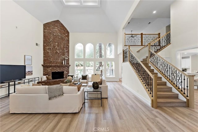6054 N Woodson Ave, Fresno, CA 93711 - living area with visible vents, high vaulted ceiling, wood finished floors, a fireplace, and stairs