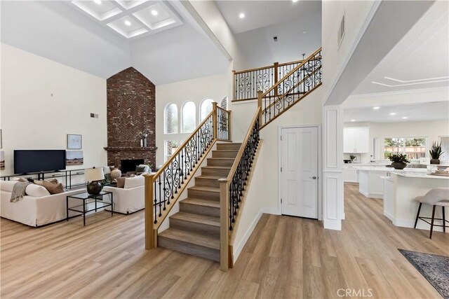 6054 N Woodson Ave, Fresno, CA 93711 - staircase featuring visible vents, a fireplace, a towering ceiling, and wood finished floors