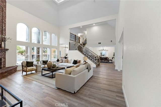 6054 N Woodson Ave, Fresno, CA 93711 - living area with stairway, a high ceiling, an inviting chandelier, and wood finished floors