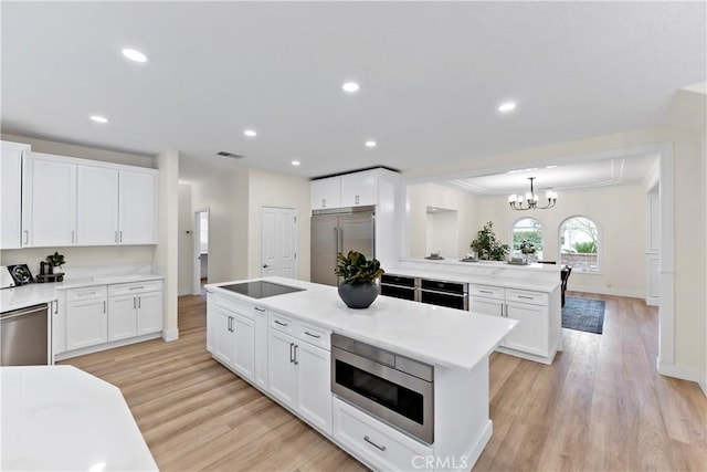 6054 N Woodson Ave, Fresno, CA 93711 - kitchen featuring built in appliances, white cabinets, light wood-type flooring, and visible vents