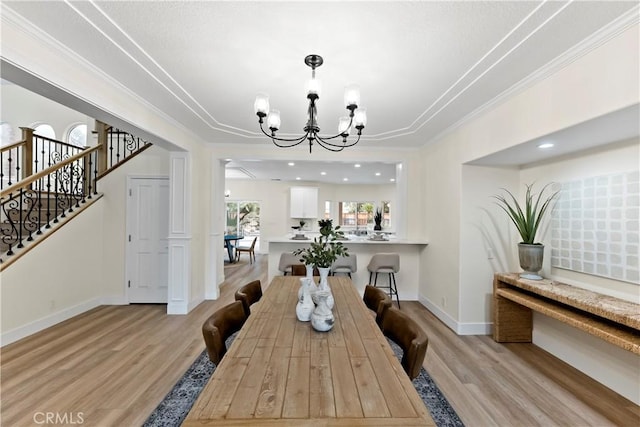 6054 N Woodson Ave, Fresno, CA 93711 - dining room featuring light wood finished floors, a notable chandelier, crown molding, and baseboards