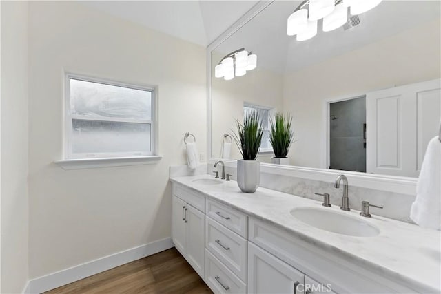 6054 N Woodson Ave, Fresno, CA 93711 - full bathroom featuring double vanity, wood finished floors, baseboards, and a sink