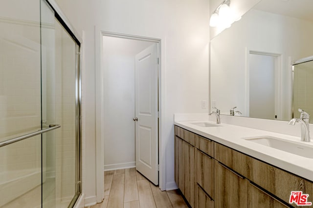 bathroom with vanity, wood-type flooring, and an enclosed shower