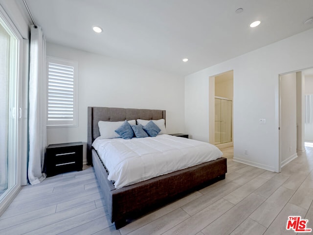 bedroom featuring ensuite bathroom and light hardwood / wood-style flooring