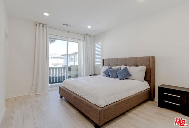 bedroom featuring access to exterior and light wood-type flooring