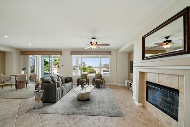 tiled living room with ceiling fan and a fireplace