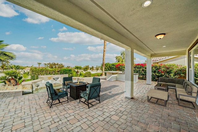 view of patio with an outdoor living space with a fire pit