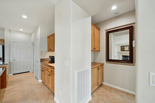 kitchen with fridge and light tile patterned floors