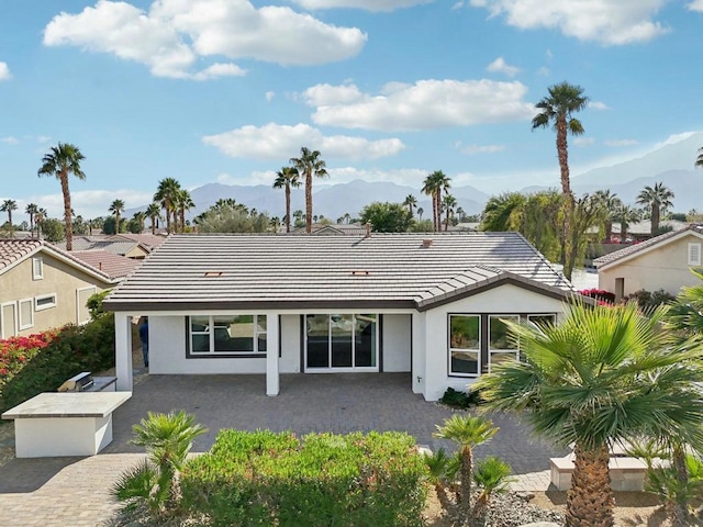 back of house with a mountain view and a patio area