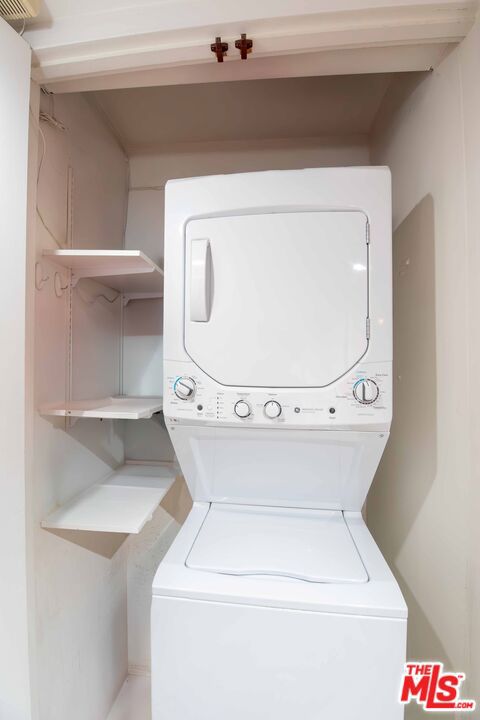 clothes washing area featuring stacked washer / dryer