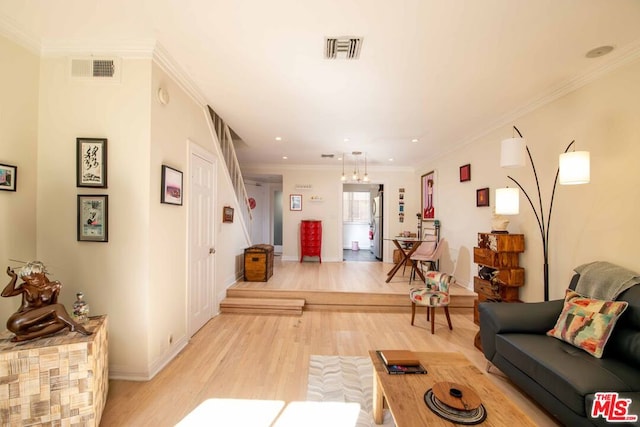 living room with ornamental molding and light hardwood / wood-style floors