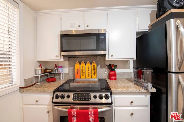 kitchen featuring white cabinetry, stainless steel appliances, and tasteful backsplash