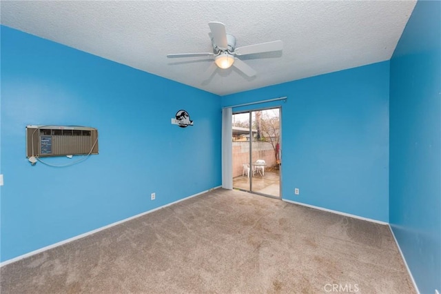 carpeted empty room featuring ceiling fan, a wall mounted air conditioner, and a textured ceiling